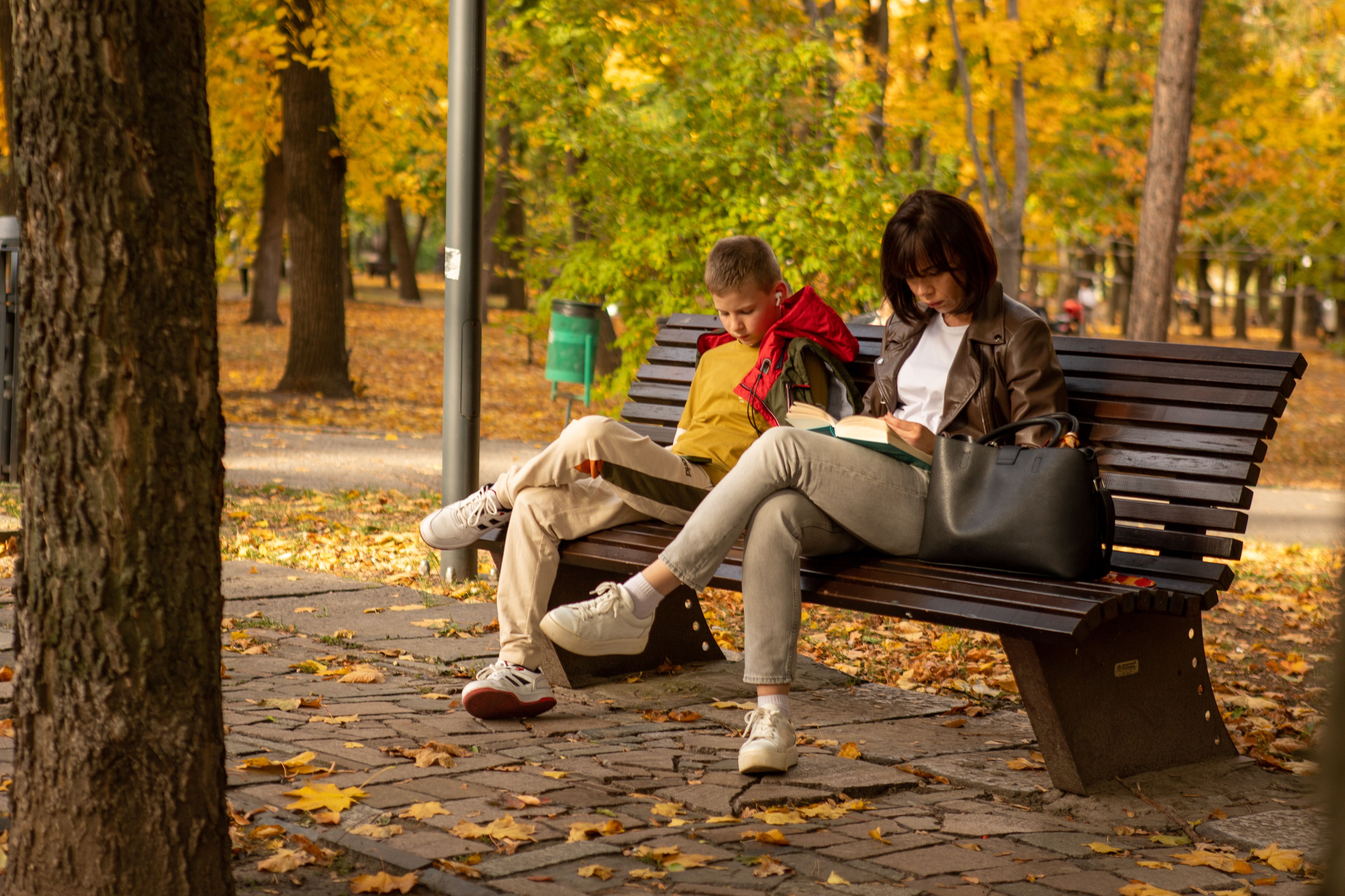 Man and Woman Smiling While Sitting on a Park Bench · Free Stock Photo