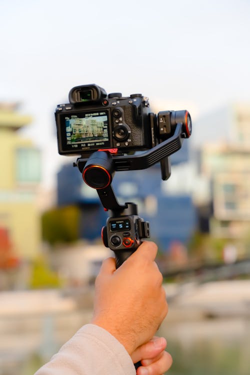 Close-up of a Person Holding a Camera on a Stabilizer 