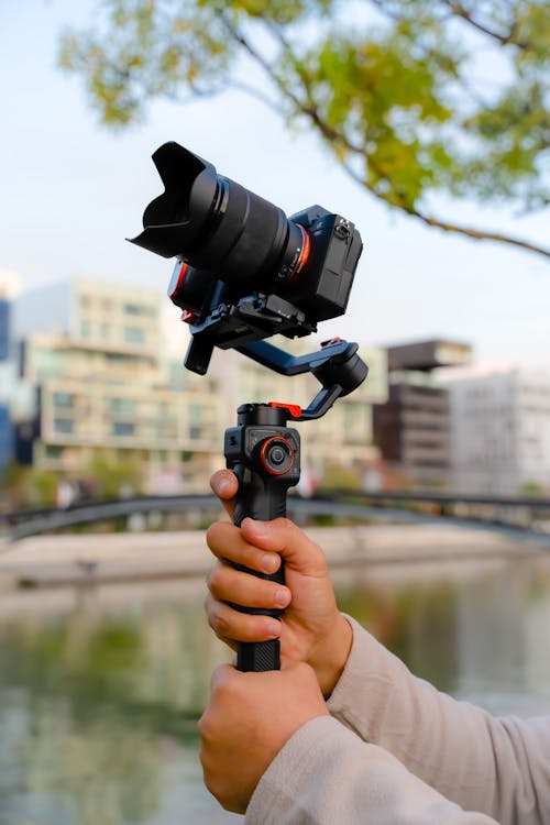 Close-up of a Person Holding a Camera on a Stabilizer