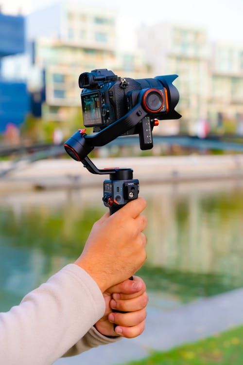 Close-up of a Person Holding a Camera on a Stabilizer 