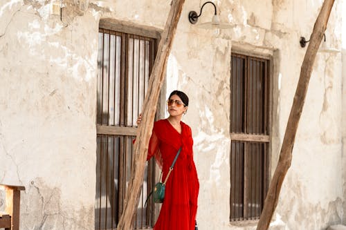 Vestido rojo junto a muro rústico
