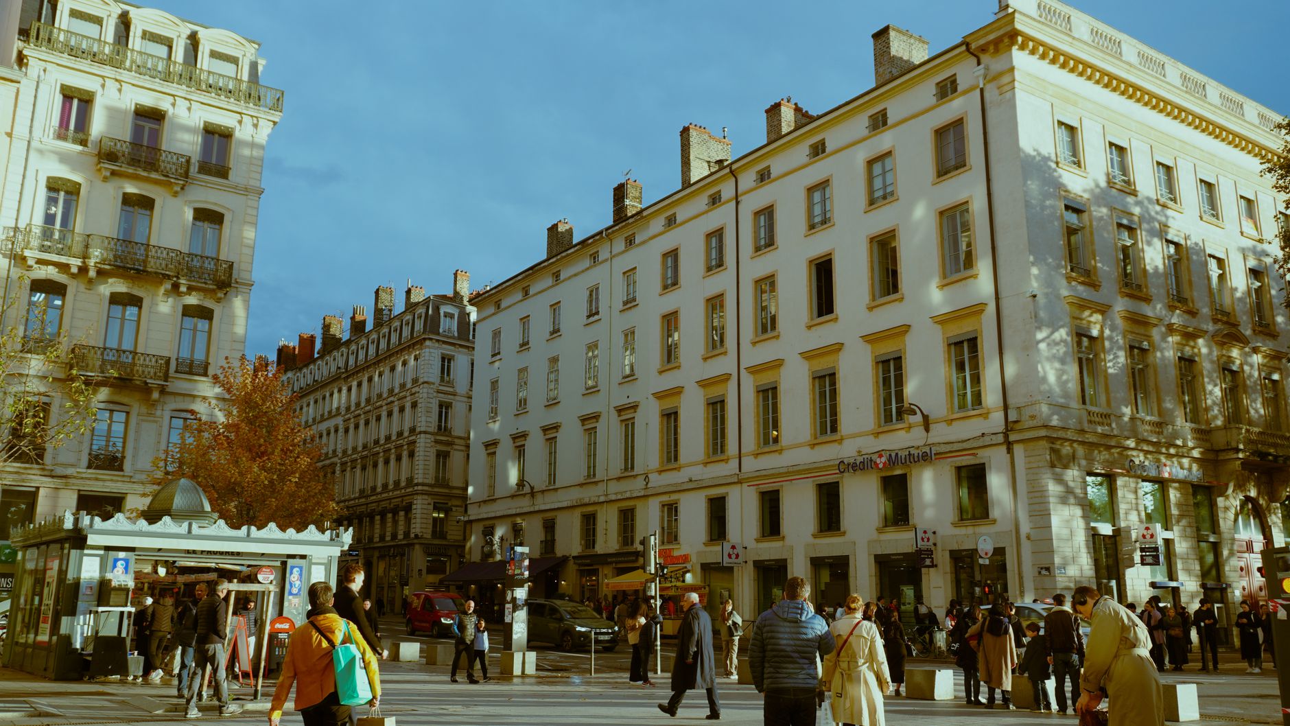 Vibrant city life on a sunny day in Lyon, France, capturing pedestrians and historic architecture.