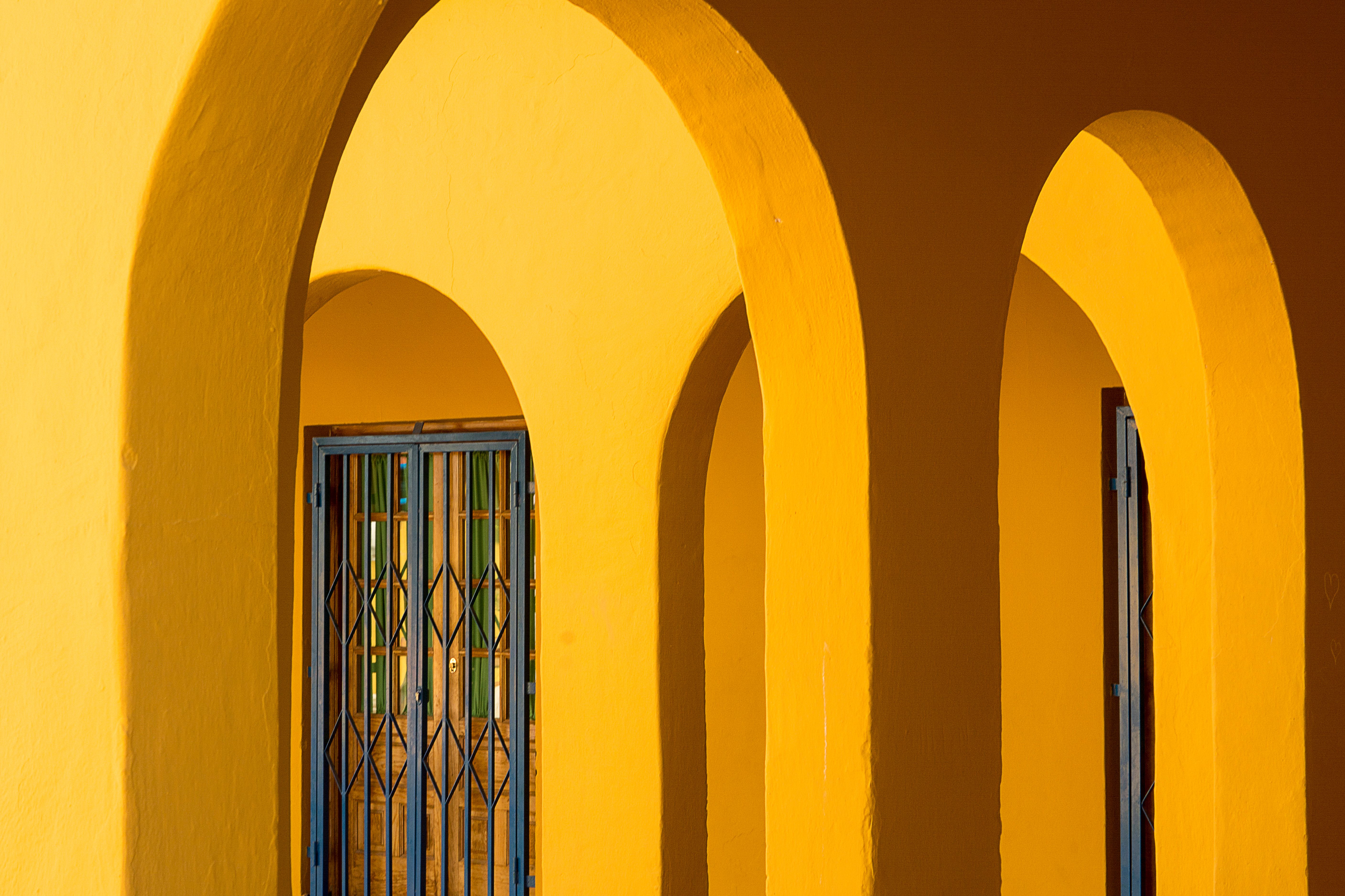 Arches in Yellow Wall · Free Stock Photo