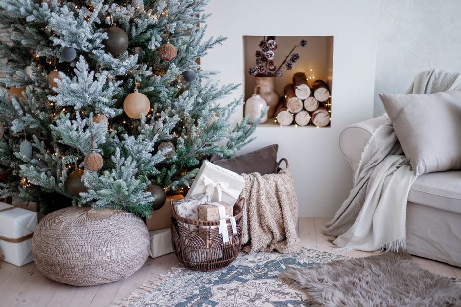 Elegant Christmas tree with rustic decor in a cozy living room setting.