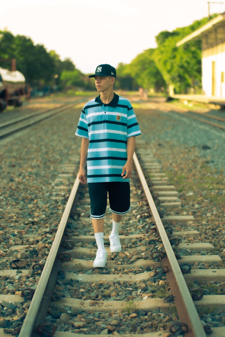 Young Man Walking On The Railway 