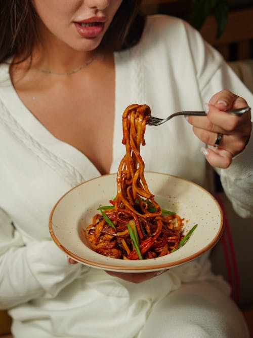 Woman Eating Pasta with Red Sauce