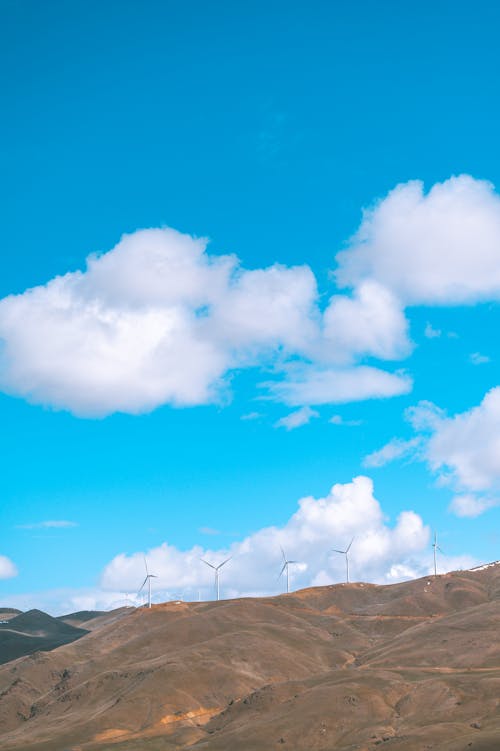 Foto d'estoc gratuïta de aerogeneradors, cel blau, muntanyes