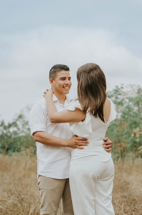 Smiling Man Embracing Woman in Countryside