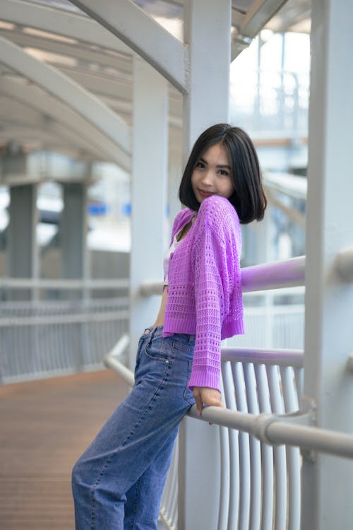 Cute Woman in Purple Sweater Posing by Railing