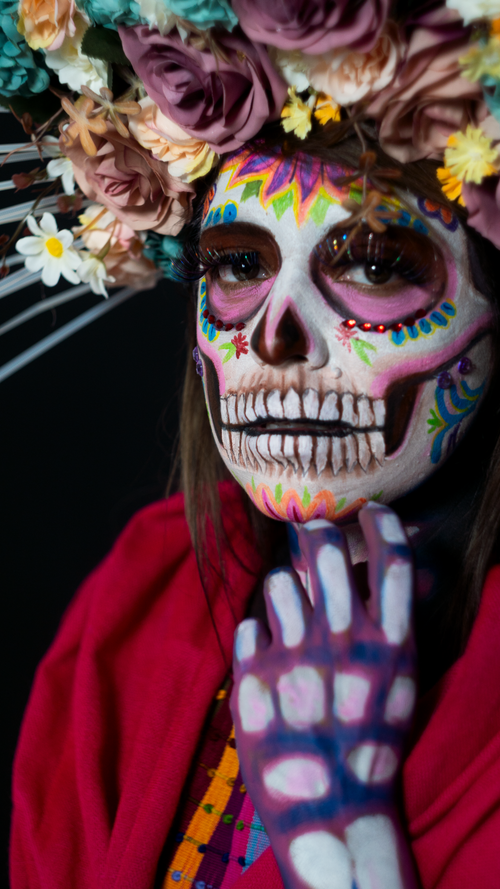 Free Colorful Day of the Dead makeup with floral headpiece, celebrating Mexican culture. Stock Photo