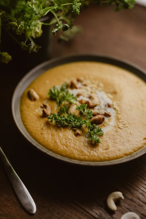 Free A warm and creamy cashew soup garnished with fresh parsley, perfect for a healthy meal. Stock Photo