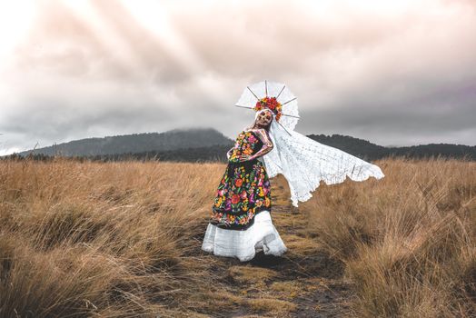 A woman in traditional dress is standing in a field