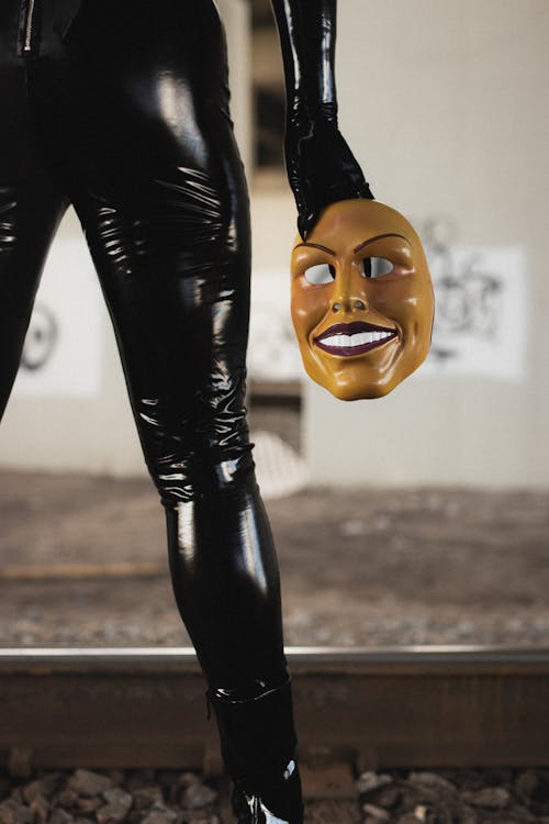 Person in Leather Clothes Standing and Holding Mask