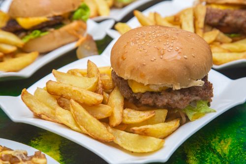 Free A delicious cheeseburger served with crispy fries on a white plate, perfect for fast food lovers. Stock Photo