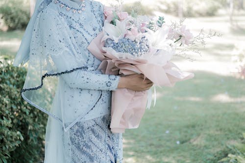 Close up of Bride in Traditional, Wedding Dress Holding Bouquet of Flowers