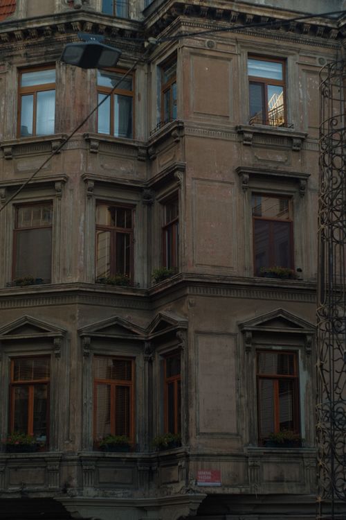 Free Detailed view of an old tenement building's facade with windows and architectural elements. Stock Photo