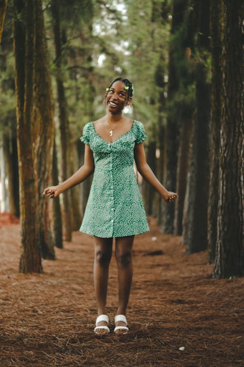 Smiling Woman in Sundress Standing among Trees