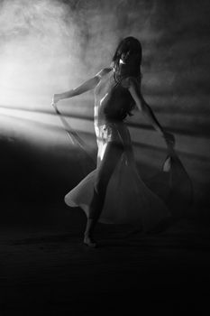 Black and white photo of a ballerina gracefully dancing in light and shadow.