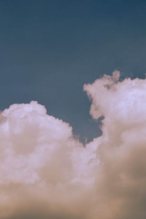 Free Serene view of fluffy white clouds floating against a calm blue sky, perfect for nature and tranquility themes. Stock Photo