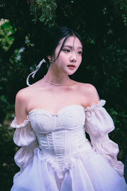 Young Woman in a White Tulle Dress Posing Outside 