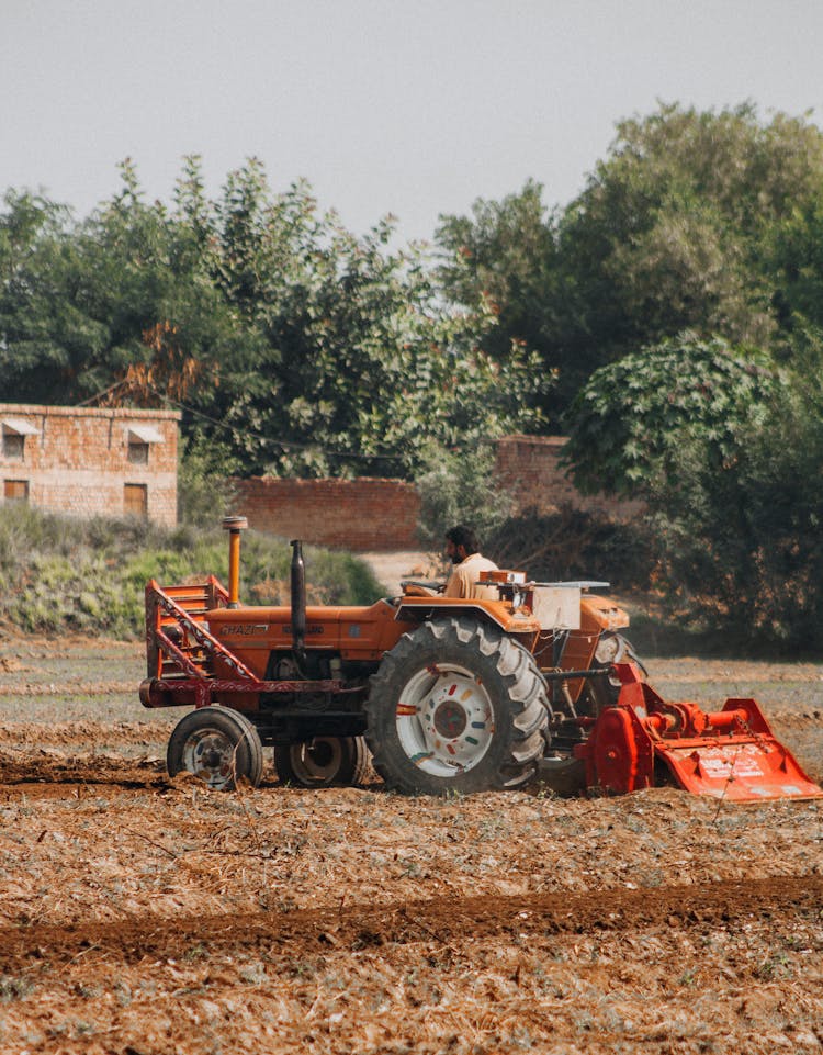 Farmer Working In Tractor On Field