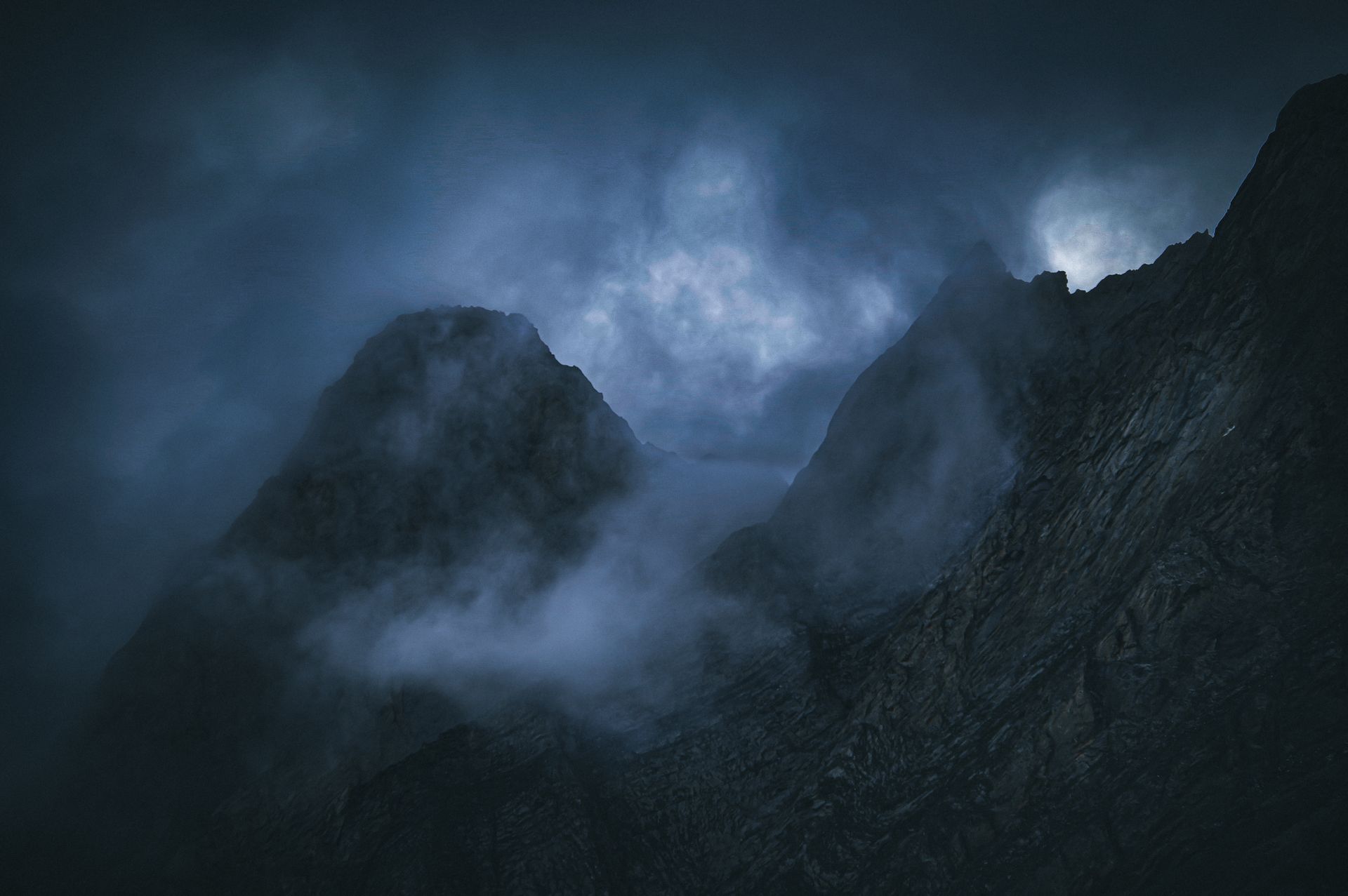 Fog-shrouded mountain peaks at twilight — photo by Andreas Schnabl on Pexels