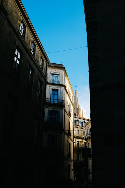 Church Tower behind Buildings and Street in Shadow in Town