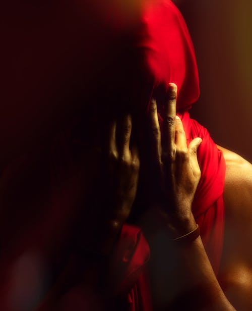 Shirtless Man with His Face Covered by Red Fabric