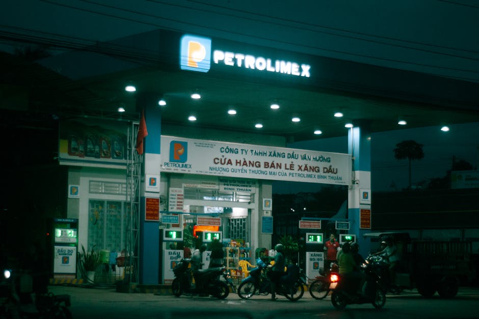 Motorcycles at a Petrolimex gas station in Vietnam at night with vibrant lighting.