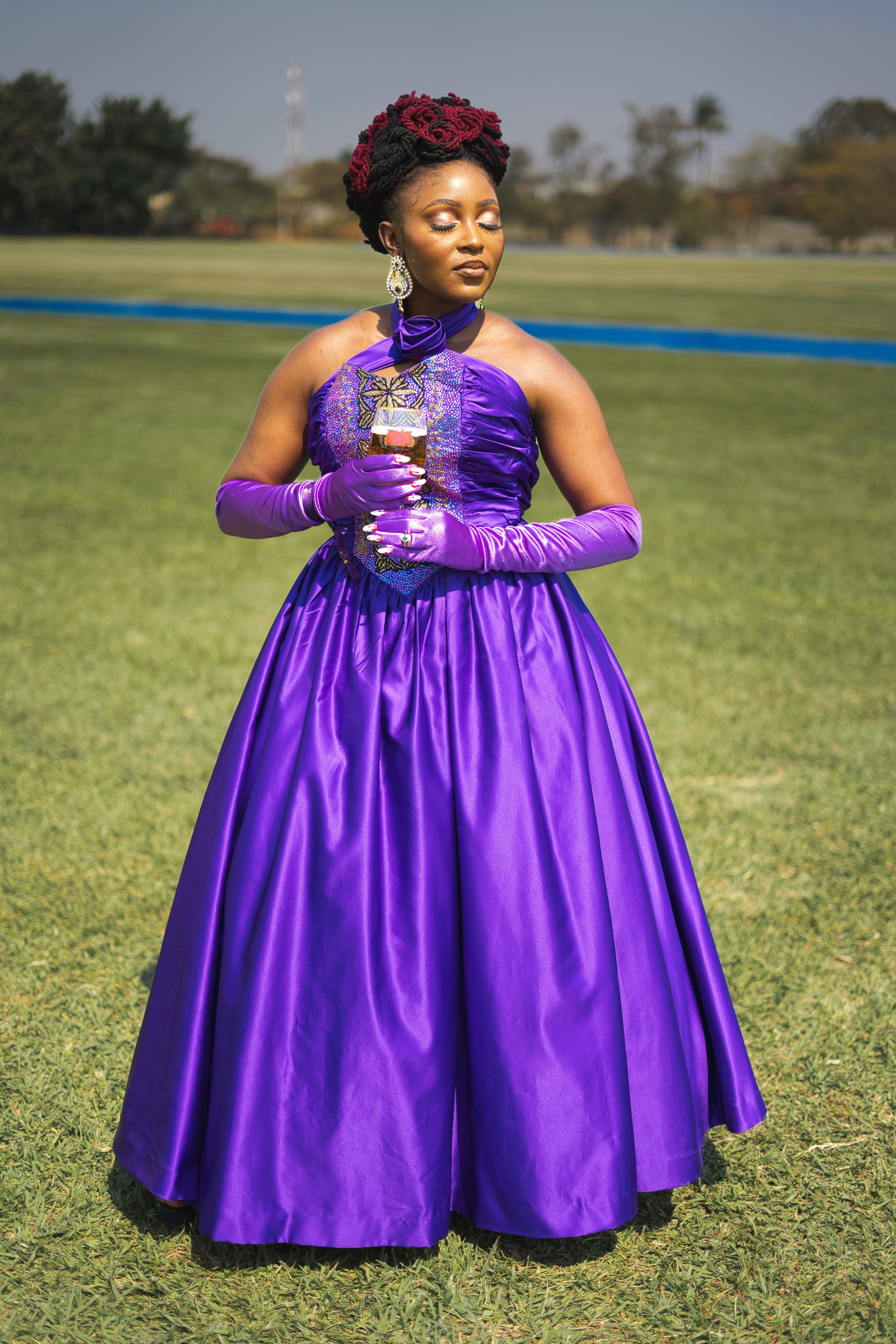 Woman in a Purple Evening Dress Standing on a Meadow with Eyes Closed ...