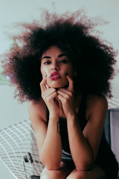 这幅肖像画描绘了一位卷发、纹身、红唇、姿势时尚的迷人女子