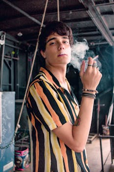 年轻人在室内摆姿势纹身时，自信地抽着烟