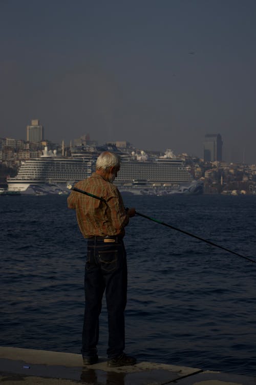 Elderly Man Fishing in Harbor in Istanbul 