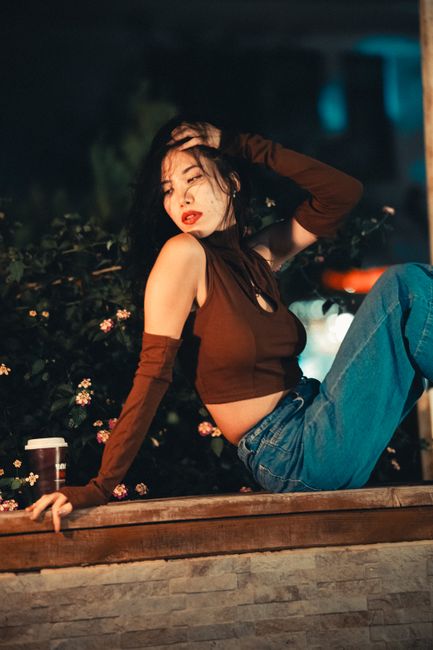 Model posing stylishly at night against an urban backdrop, exuding elegance and fashion.
