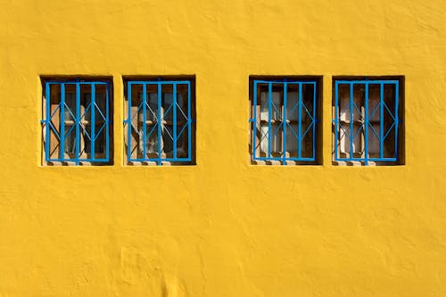 Bars on Windows on Yellow Wall