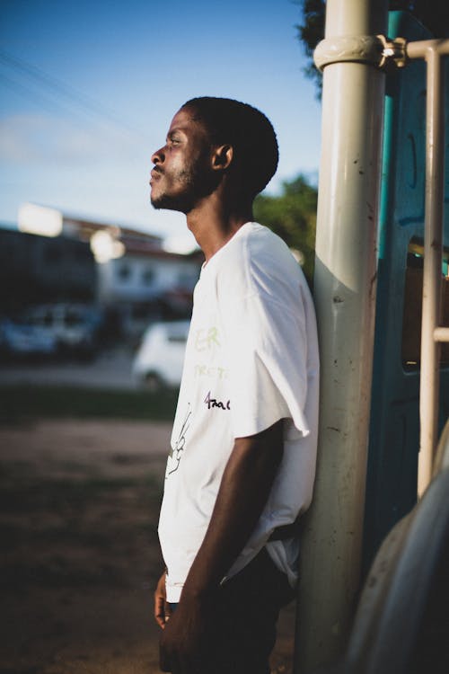 Pensive Man Standing by the Downpipe Looking at the Sunrise