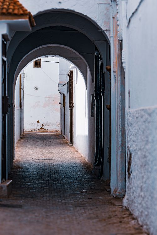 Free Charming view of a historic arched alleyway in a serene old town setting. Stock Photo