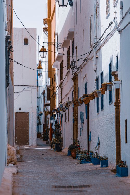 Free Explore this picturesque narrow street with white walls and rustic architecture in a historic urban town. Stock Photo