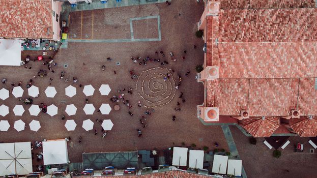 Aerial view of a piazza with umbrellas and people in Alba, Italy.