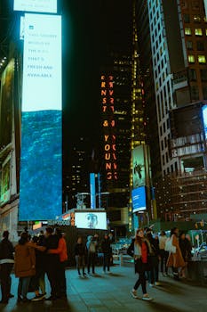 Vibrant night scene in Times Square with illuminated billboards and busy streets.