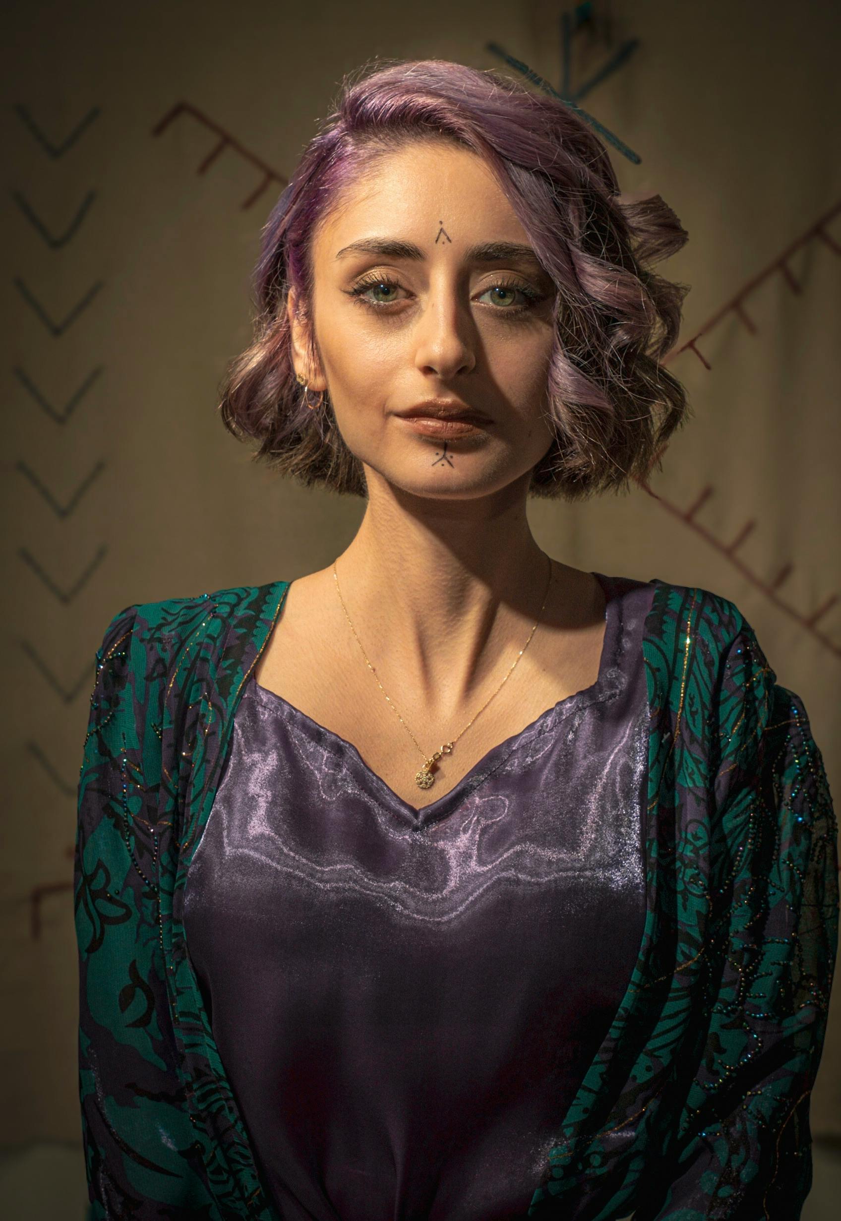 Artistic portrait of a woman with purple hair and tribal makeup, set in Istanbul, Turkey.