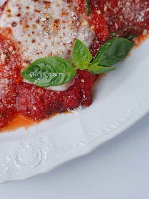 Part of a Plate with Tomato Sauce and Basil
