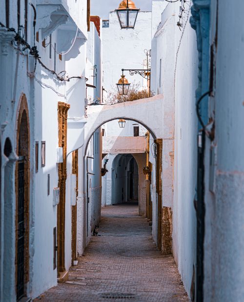Free Serene view of a narrow cobblestone alley in Rabat, featuring white townhouses and decorative lanterns. Stock Photo