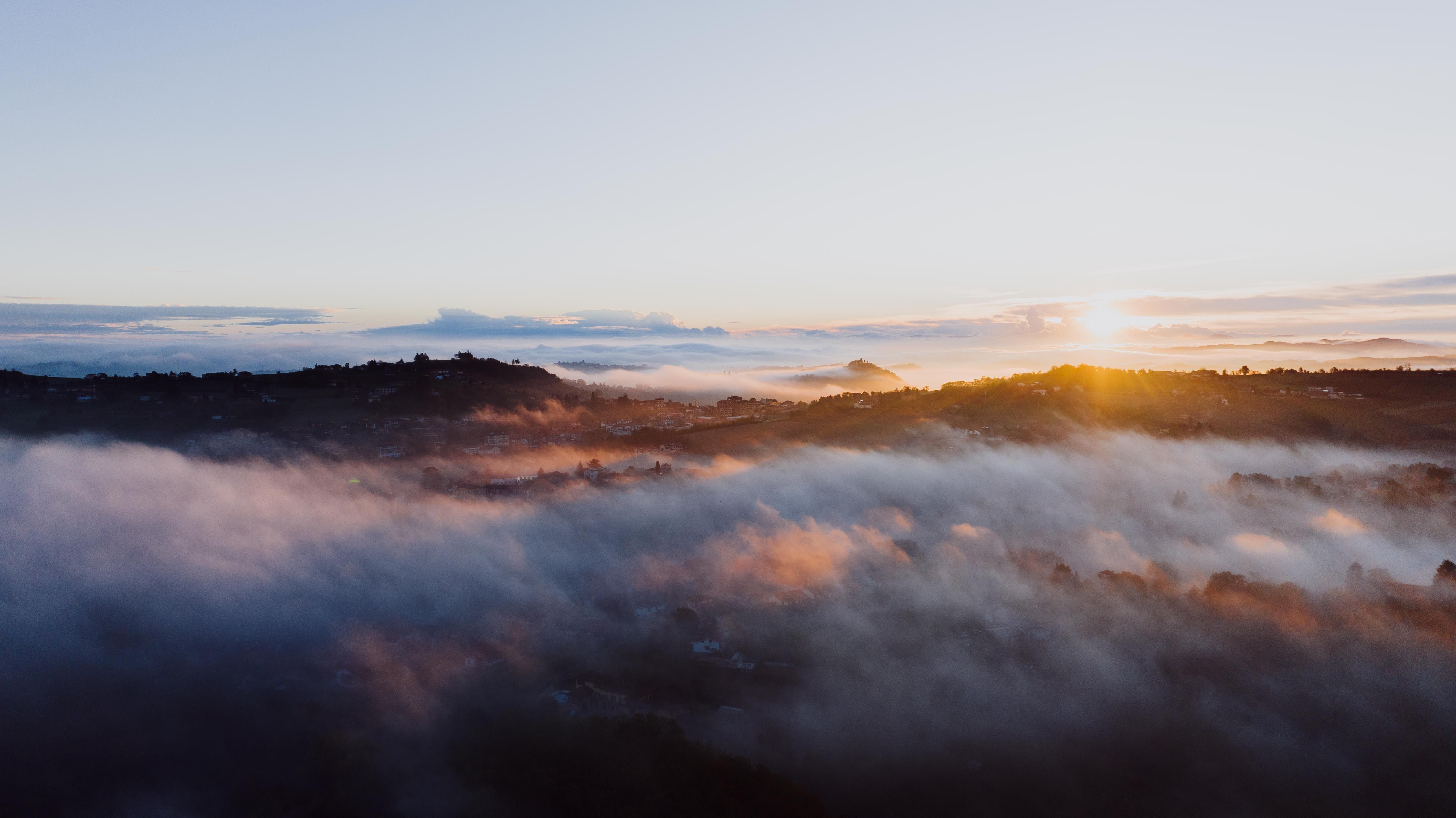 A breathtaking sunrise over fog-covered hills in Costigliole d'Asti, Piemonte, Italy.