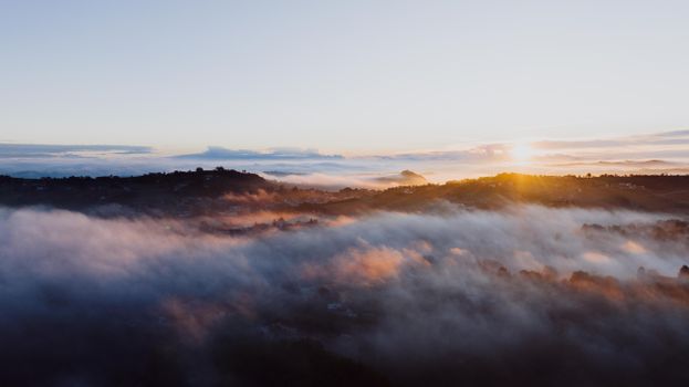 A breathtaking sunrise over fog-covered hills in Costigliole d'Asti, Piemonte, Italy.