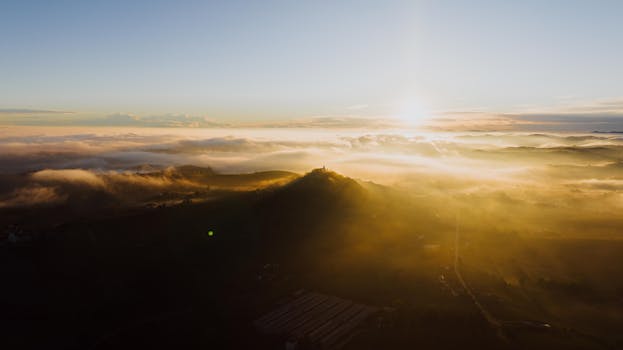 Aerial view of a sunrise over the mist-covered hills of Costigliole d'Asti, Italy.