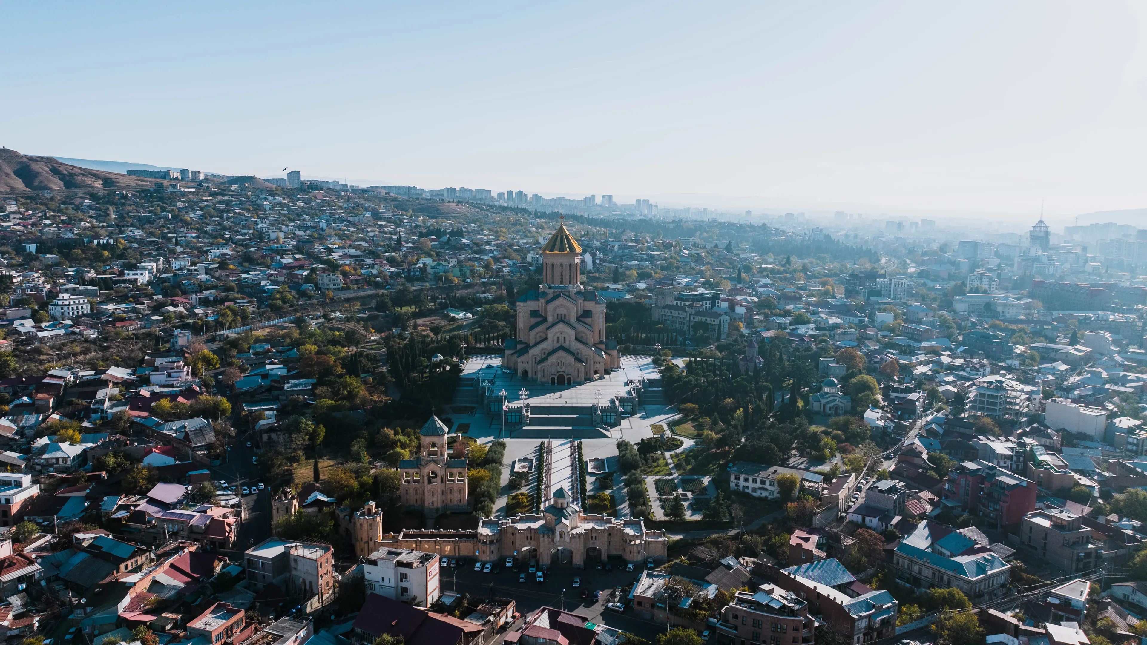 A stunning aerial view capturing the Holy Trinity Cathedral amidst the cityscape of Tbilisi, Georgia.