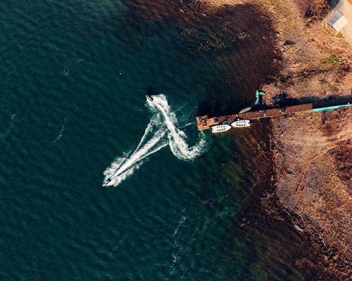 Free Aerial view of motorboats leaving a pier at Sambalpur, India, with scenic seashore. Stock Photo