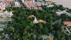 A vibrant aerial view of Wat Phnom, surrounded by lush greenery in Phnom Penh, Cambodia, capturing its significance and cityscape.