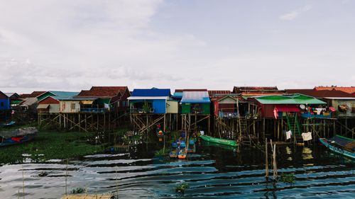 Free Colorful stilt houses line the shore of Kampong Khleang, reflecting in the water below. Stock Photo